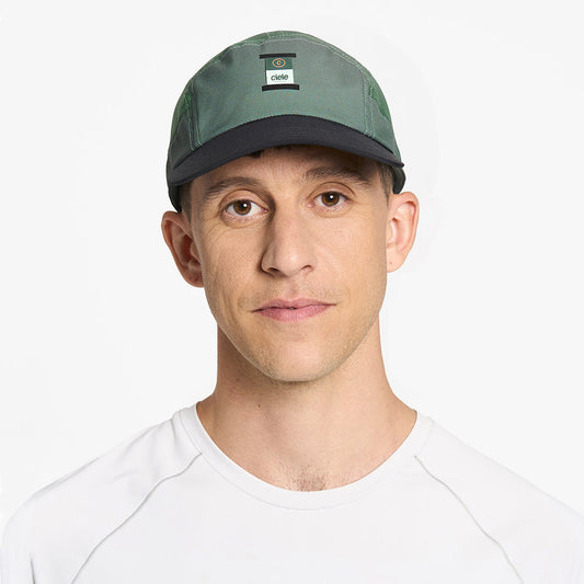 front view of ciele athletics GOCap Comp C cube unisex running hat in silver pine color on a model