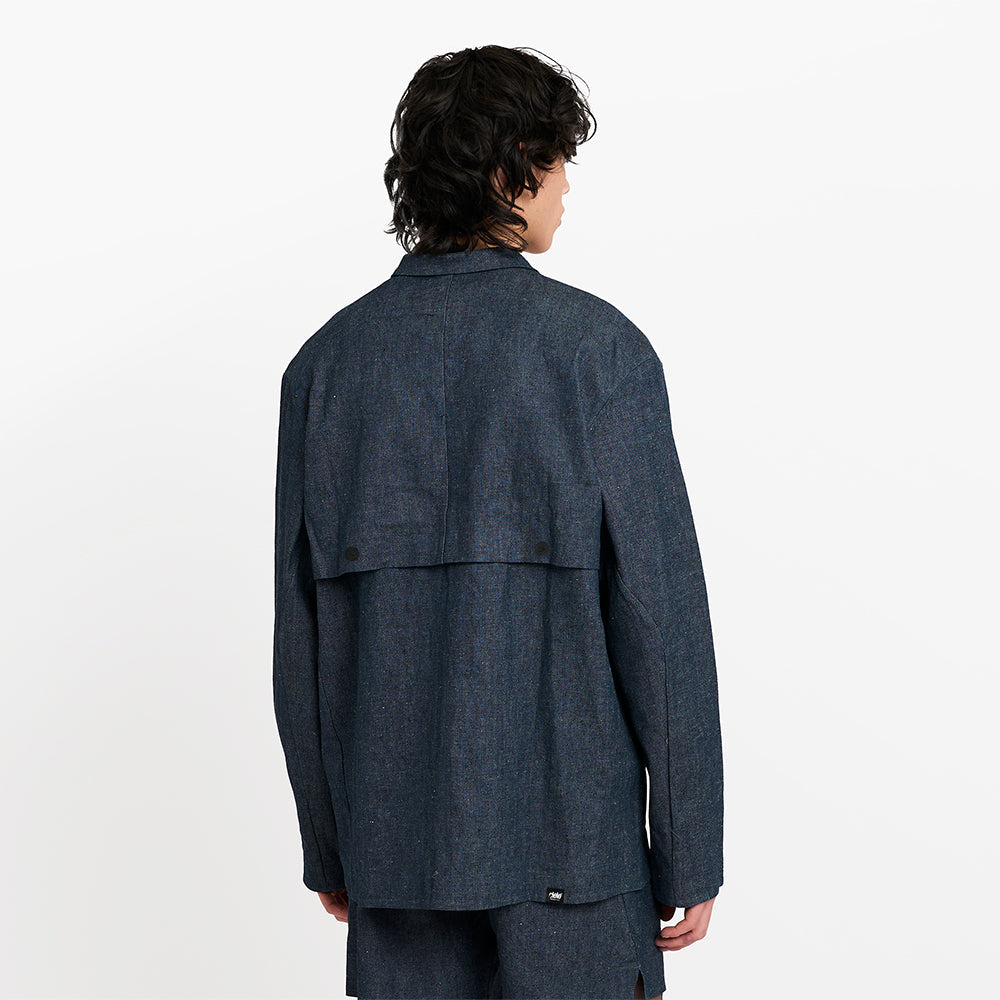 back view of ciele athletics CCJacket unisex running jacket from the Lifestyle Edition collection, in denim indigo color, on a model