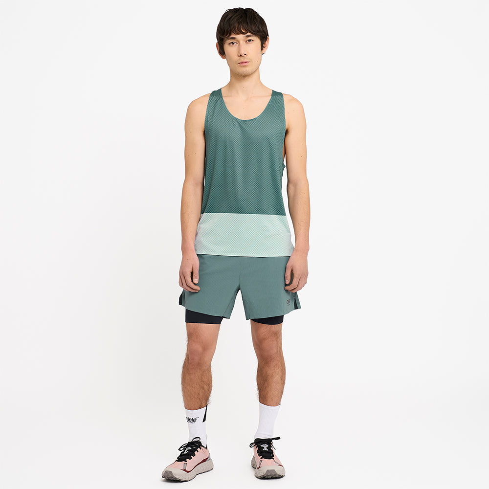 full picture of a model wearing the ciele athletics lightweight, race ready and performance driven singlet named RDSinglet in turquoise color from the lifetime edition, with the WRKShort in silver pine