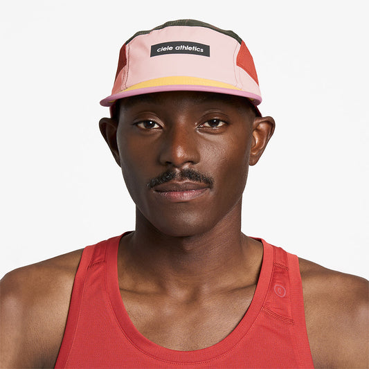 front view of ciele athletics GOCap Field Iconic Bar unisex running hat in peachskin seaweed color on a model