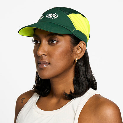 side view of the ciele athletics FTSCap unisex running hat with a curved brim in emerald color, on a model