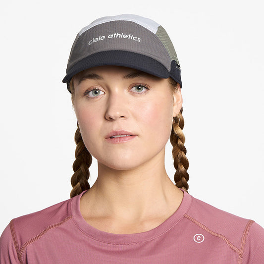 front view of ciele athletics FSTCap SC Field Iconic SL unisex running hat in whitaker color on a model