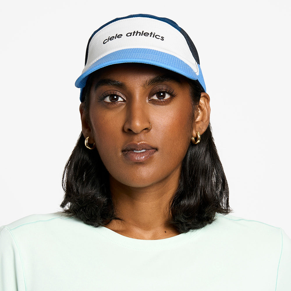 front view of the ciele athletics FTSCap unisex running hat in white cobalt color, on a model