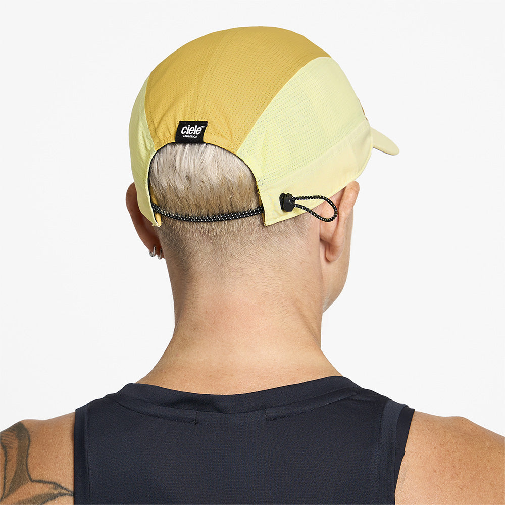 back view of ciele athletics FSTCap SC Comp Iconic VC unisex running hat in dark ochre sulfur color on a model