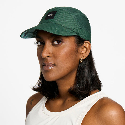 front view of the ciele athletics FTSCap unisex running hat with a curved brim in emerald color, on a model