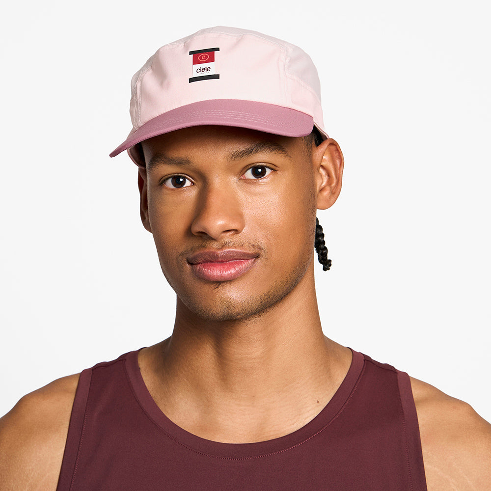 front view of the ciele athletics GOCap with a curved brim unisex running hat in peachskin color, on a model