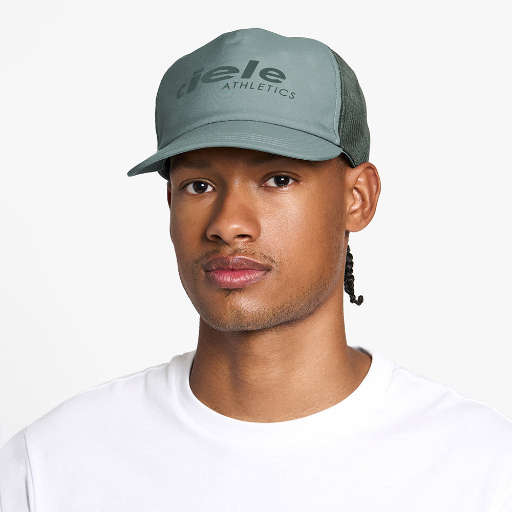 front view of the ciele athletics TRLCap unisex running hat with a curved brim in silver pine color, on a model