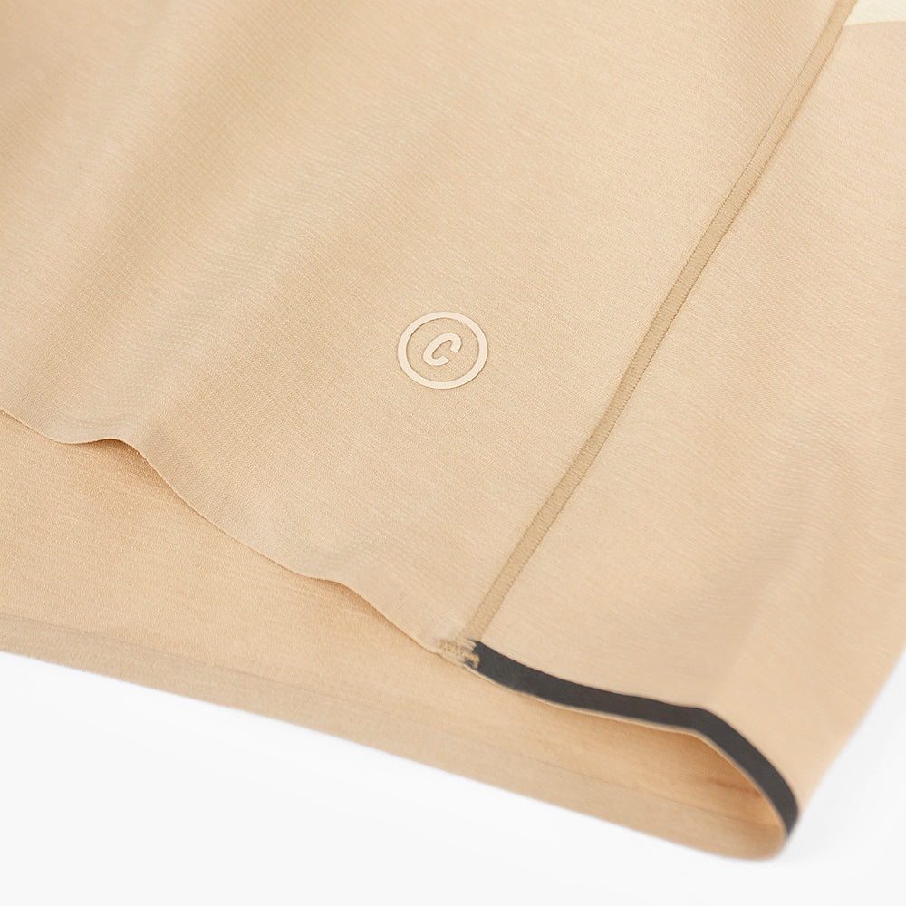 close view of the C logo and reflective details on the ciele athletics TRNShort 4 inch with a brief in safari color